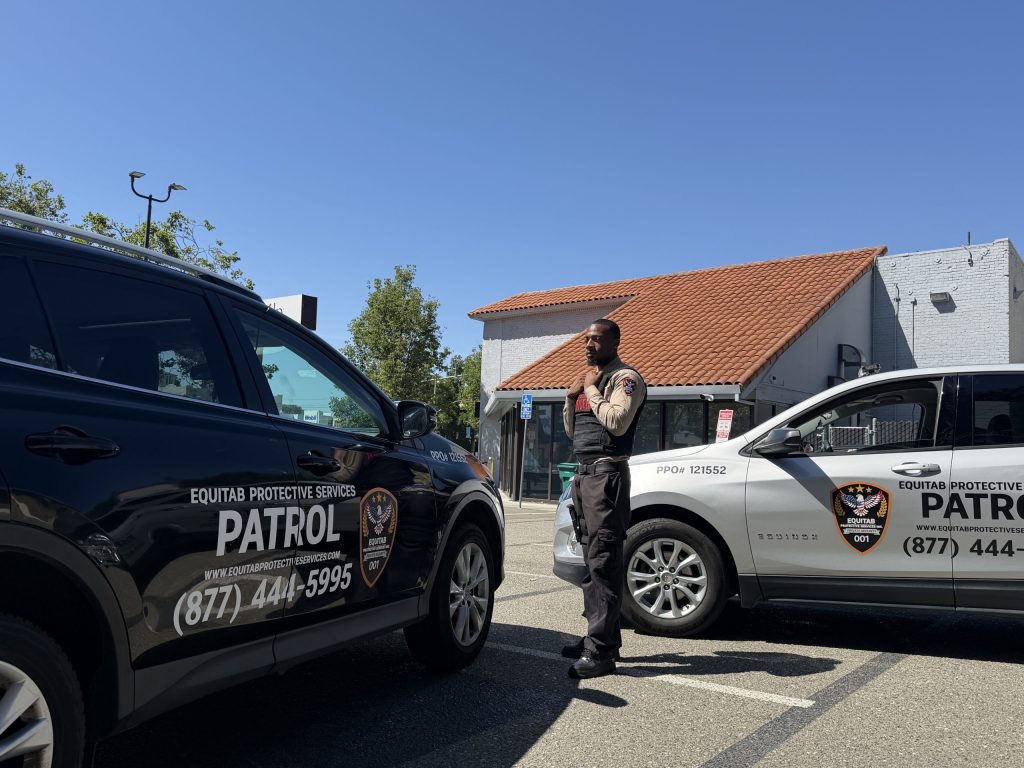 Equitab security officer with marked Equitab patrol vehicles